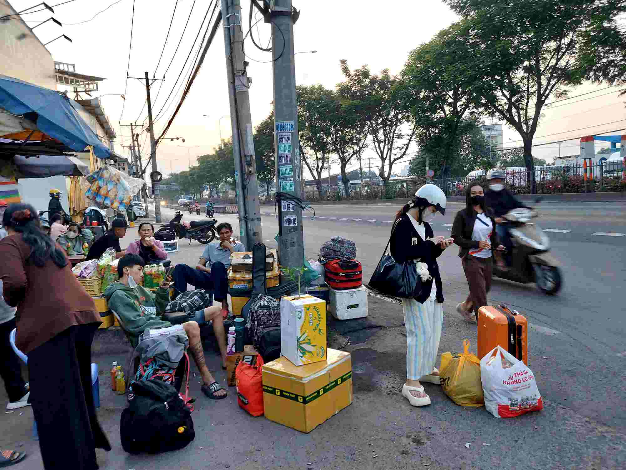 Passengers wait for "illegal buses" in front of Tam Binh 2 gas station on Highway 1, instead of going to Mien Dong bus station. Photo: Minh Quan