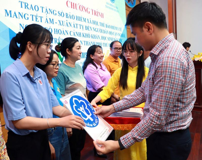 Mr. Tran Dung Ha - Deputy Director of Ho Chi Minh City Social Insurance - presented social insurance books and health insurance cards to households in Thu Duc City, Ho Chi Minh City. Photo: Duc Long