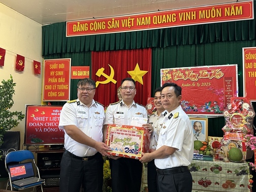 Thuong ta Trieu Thanh Tung (ngoai cung ben trai), Pho Tham muu truong BTL Vung 2 Hai quan, truong doan cong tac tang qua, chuc Tet cac can bo, chien si tren nha gian.