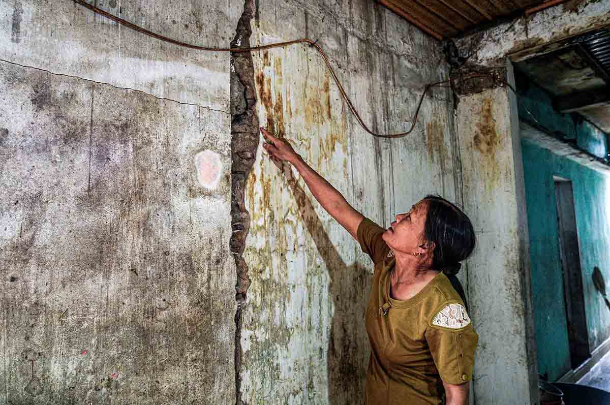 Bà Liễu chỉ lên vết nứt tường nhà mình. Ảnh: Trần Tuấn.