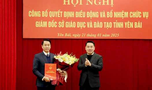 Chủ tịch UBND tỉnh Yên Bái Nguyễn Tuấn Anh trao quyết định và tặng hoa chúc mừng tân Giám đốc Sở Giáo dục và Đào tạo Luyện Hữu Chung. Ảnh: Thanh Chi