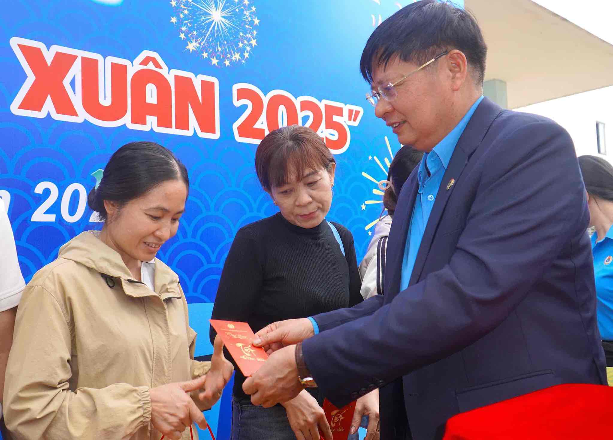 Vice President of the Vietnam General Confederation of Labor Phan Van Anh wishes a happy new year and gives lucky money gifts to union members and their relatives before boarding the train to return home for Tet. Photo: HAC