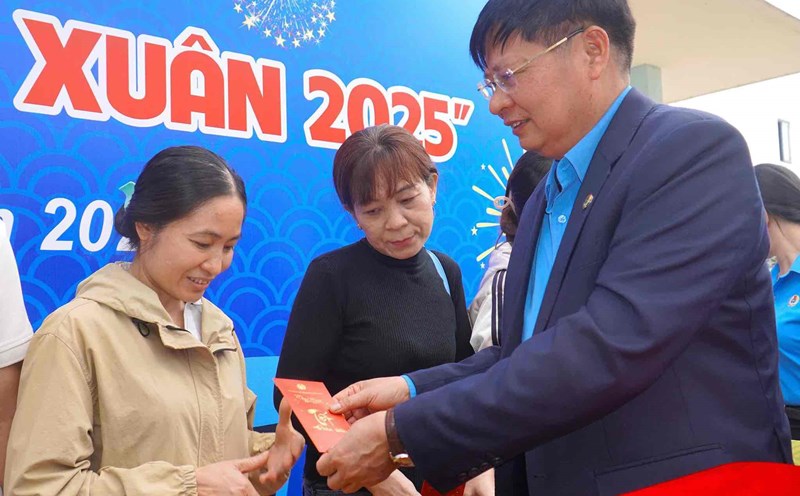 Vice President of the Vietnam General Confederation of Labor Phan Van Anh wishes a happy new year and gives lucky money gifts to union members and their relatives before boarding the train to return home for Tet. Photo: HAC
