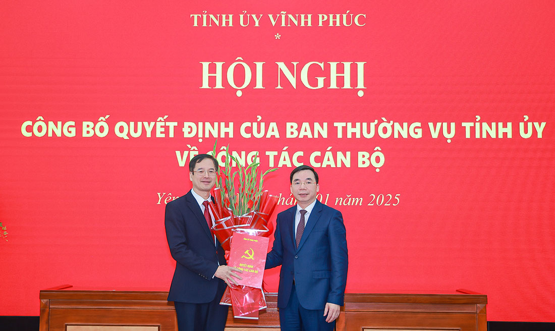 Standing Deputy Secretary of Vinh Phuc Provincial Party Committee Bui Huy Vinh presented the Decision and flowers to congratulate the new Secretary of Yen Lac District Party Committee Lai Huu Tuyen. Photo: Tra Huong
