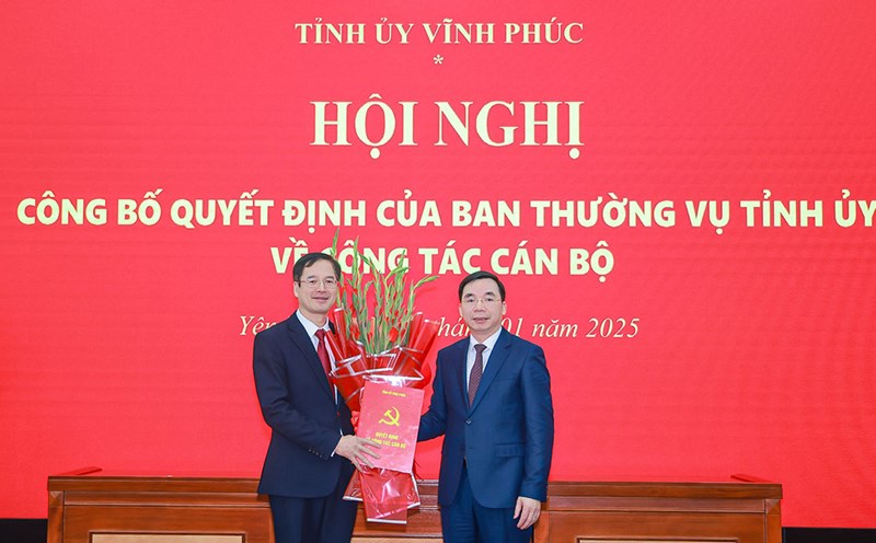 Standing Deputy Secretary of Vinh Phuc Provincial Party Committee Bui Huy Vinh presented the Decision and flowers to congratulate the new Secretary of Yen Lac District Party Committee Lai Huu Tuyen. Photo: Tra Huong