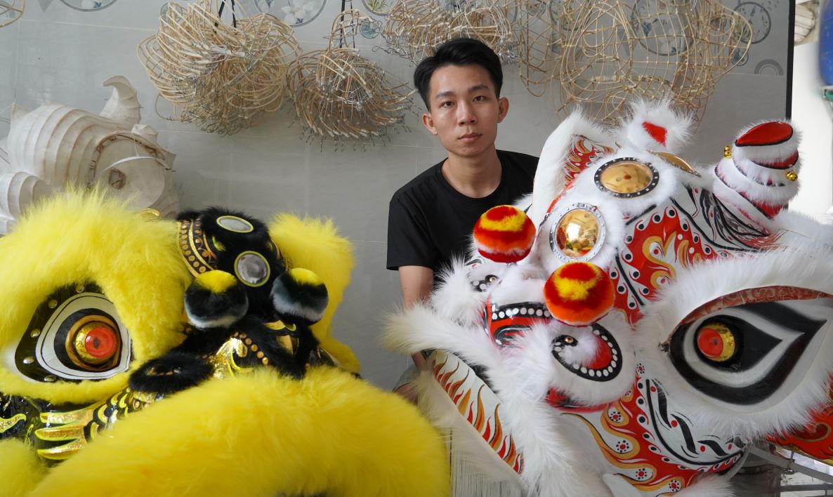 Pham Viet Lam with the lion heads he made.