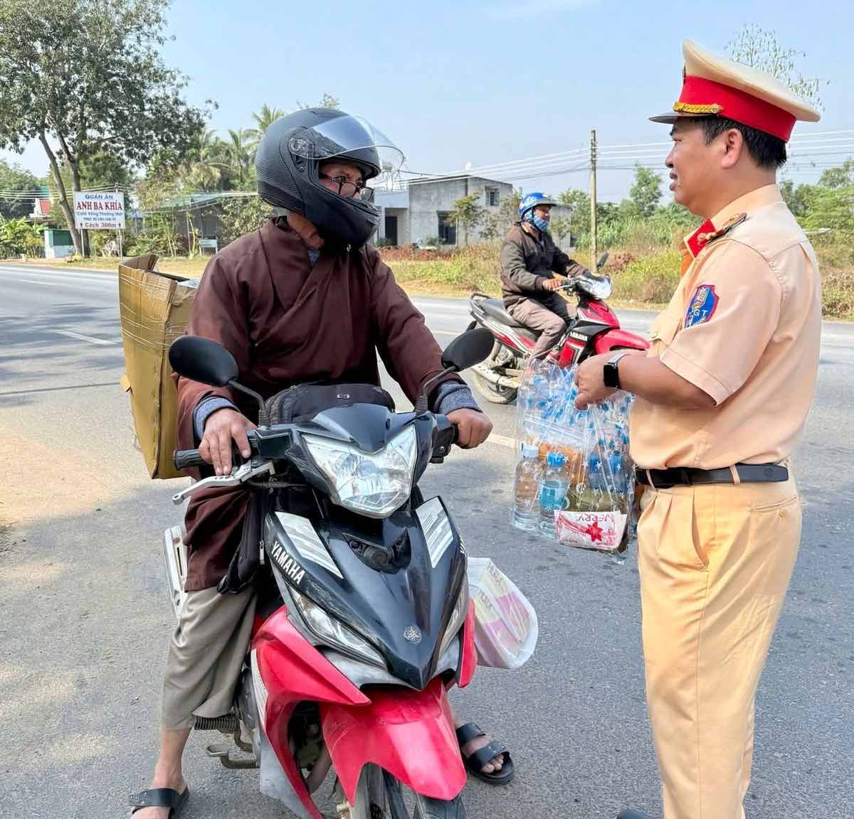 Ngoai tang nuoc uong, CSGT con tham hoi, chuc suc khoe nguoi dan. Anh: Cong an 