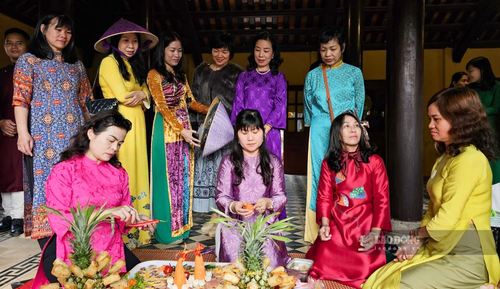 Nhung nguoi phu nu trong ta ao dai duyen dang dang tap trung che bien mon nem cong cha phuong, mot mon an doi hoi su ti mi va kheo leo, thuong duoc phuc vu vao nhung ngay Tet xua.