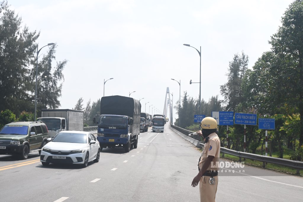 Traffic Police of Tien Giang and Ben Tre provinces coordinate to regulate traffic at Rach Mieu bridge. Photo: Thanh Nhan