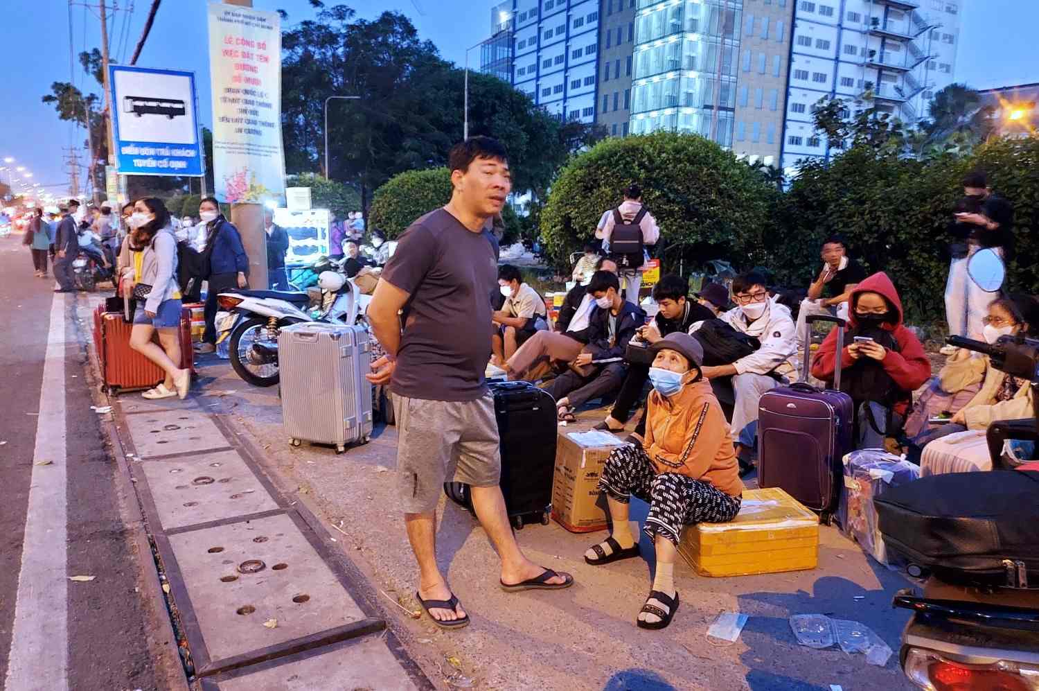 People waiting for buses on Do Muoi Street (in front of National Highway 1), near Linh Trung 1 Export Processing Zone. Photo: Minh Quan