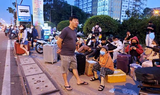 Người dân chờ đón xe trên đường Đỗ Mười (trước lộ Quốc lộ 1), gần Khu chế xuất Linh Trung 1.  Ảnh: Minh Quân