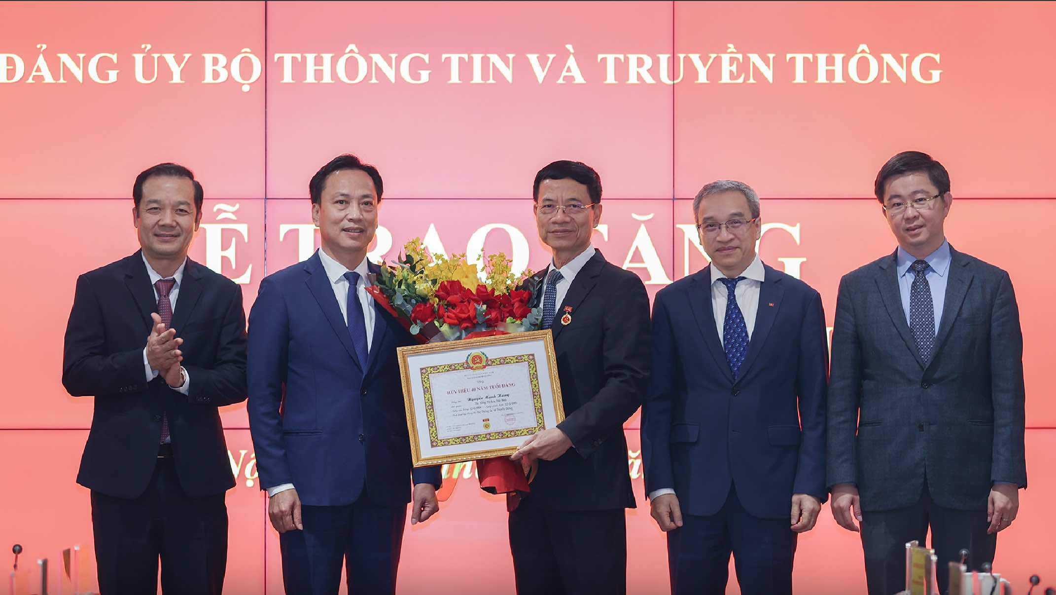 Minister Nguyen Manh Hung receives 40-year Party membership badge. Photo: MIC