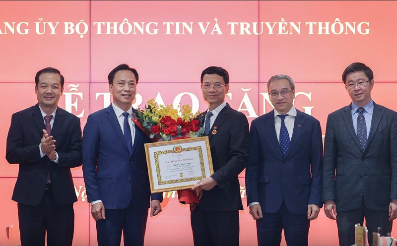 Minister Nguyen Manh Hung receives 40-year Party membership badge. Photo: MIC