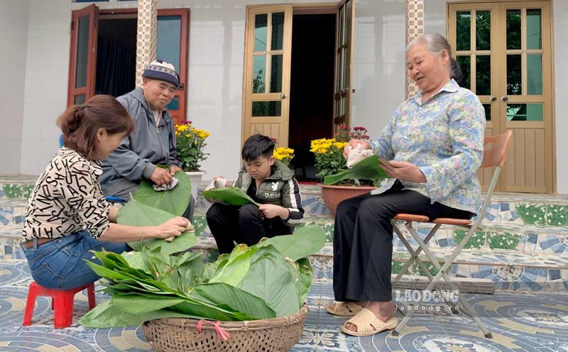 Ms. Thu, her elderly parents and son prepare dong leaves to wrap banh chung. Photo: Luong Ha