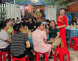 Ms. Nguyen Thi Kim Hong takes a photo with workers at the boarding house. Photo: Anh Tu