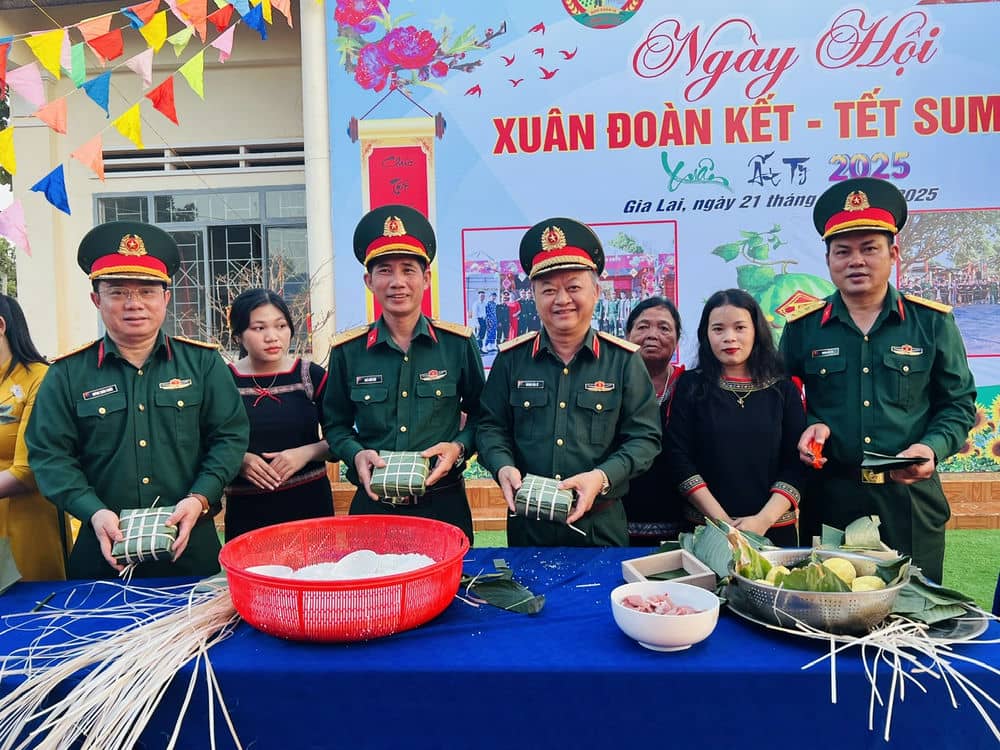 Major General Hoang Van Sy (4th from left) and leaders of Company 715 with people wrapping banh chung. Photo: Thanh Tuan