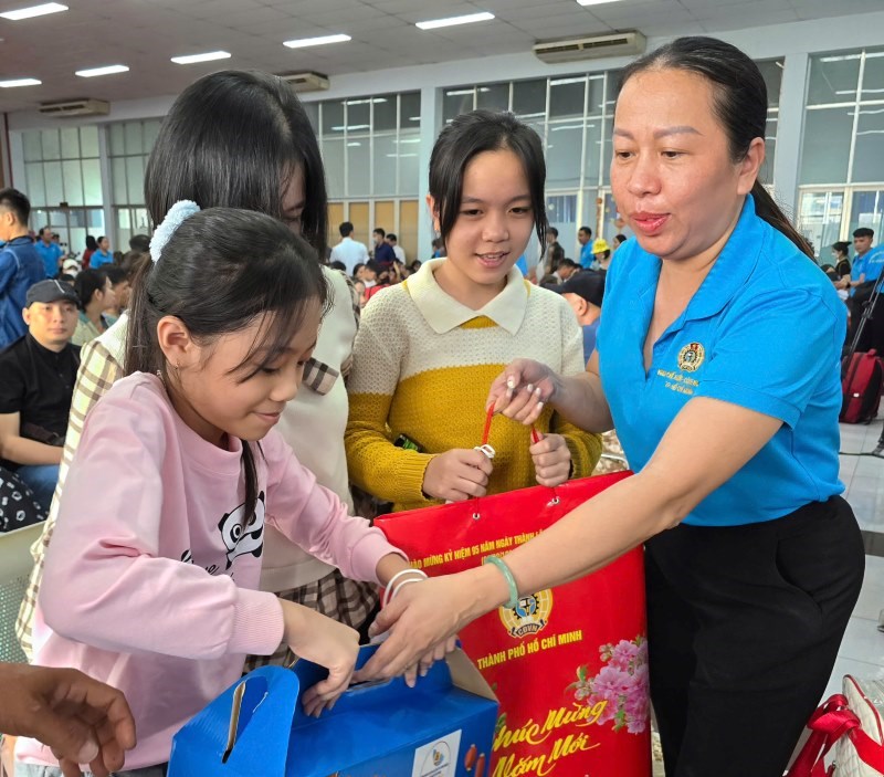 Ba Vu The Van - Chu tich Cong doan cac Khu che xuat & cong nghiep TPHCM - tang qua gia dinh cac cong nhan ve que don Tet. Anh: Nam Duong