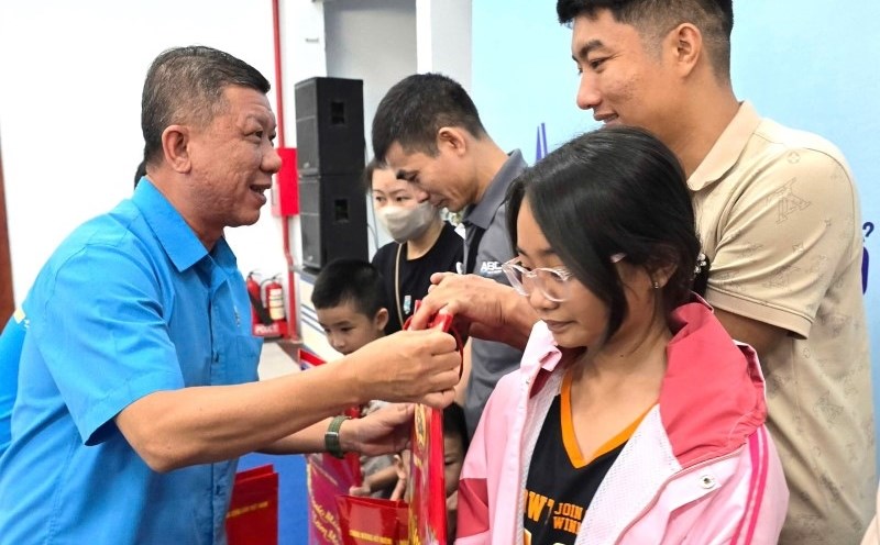 Mr. Tran Doan Trung - Permanent Vice President of Ho Chi Minh City Labor Federation - presents gifts to workers' families. Photo: Nam Duong