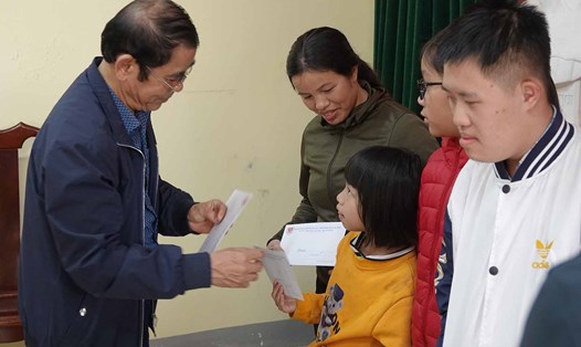 Đại diện Hội Bảo trợ người khuyết tật và trẻ mồ côi Hà Tĩnh trao quà cho các trẻ khuyết tật, đại diện gia đình trẻ khuyết tật, mồ côi ở Hà Tĩnh. Ảnh: Trần Tuấn.