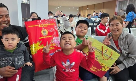 Gia đình công nhân hạnh phúc khi nhận được tấm vé của chuyến tàu mùa Xuân. Ảnh: Nam Dương