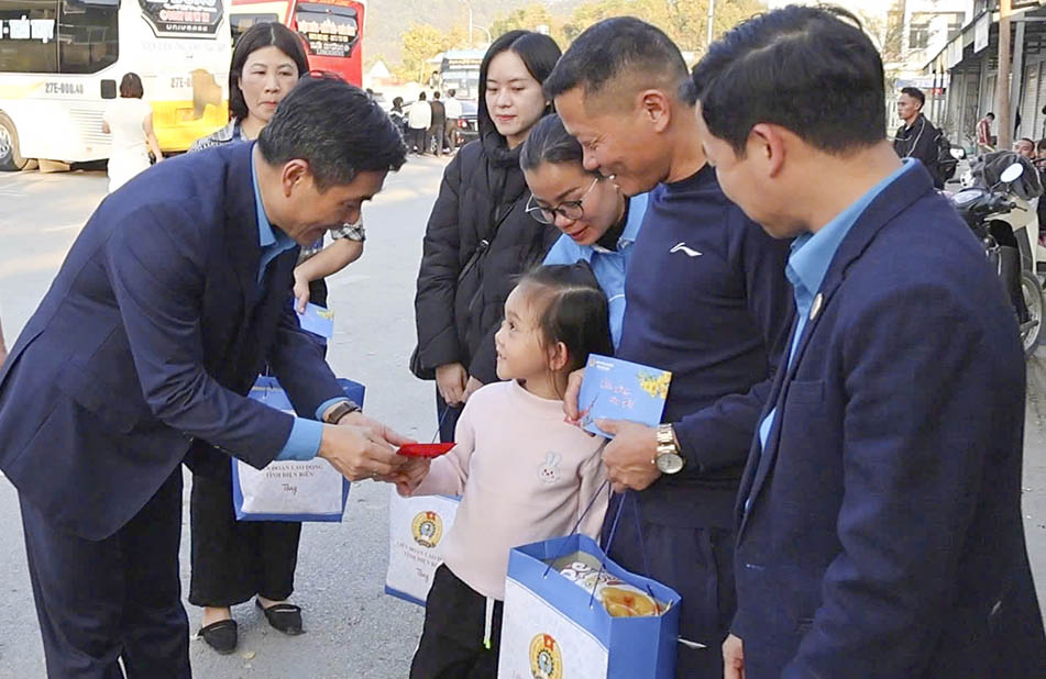 Ông Tẩn Minh Long - Chủ tịch LĐLĐ tỉnh Điện Biên tặng lì xì cho con của đoàn viên công đoàn được hỗ trợ tiền vé xe về quê đón Tết. Ảnh: Minh Thuận
