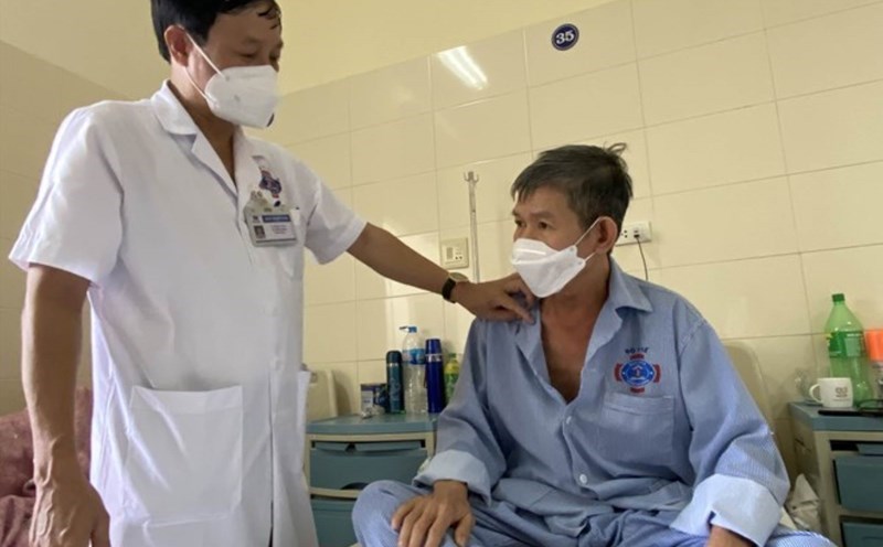 Doctor examines patient with health insurance card. Photo: Thuy Linh