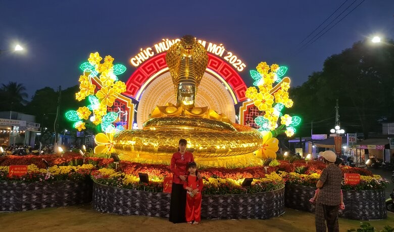 People take spring photos with the mascot of the year of the Snake 2025. Photo: Nhat Ho