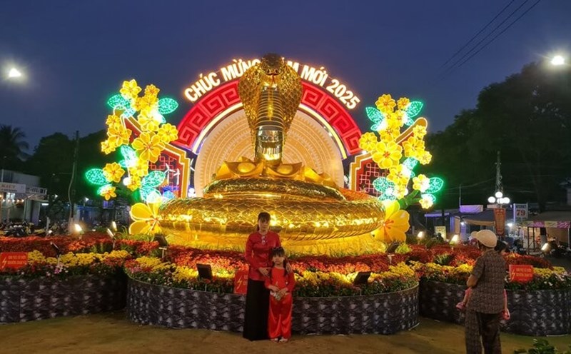 People take spring photos with the mascot of the year of the Snake 2025. Photo: Nhat Ho