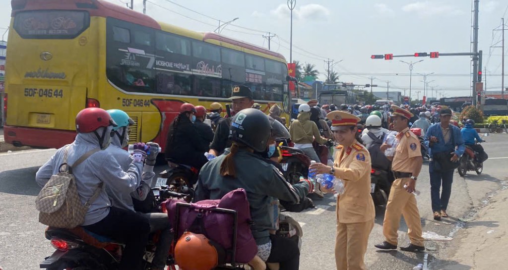 Luc luong Canh sat giao thong thuoc Phong CSGT Cong an tinh Tien Giang phat nuoc mien phi cho nguoi dan ve que tren Quoc lo 1. Anh: Thanh Nhan