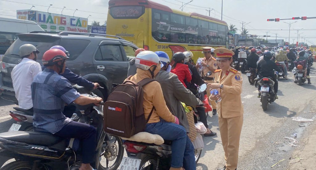 Traffic Police force of the Traffic Police Department of Tien Giang Province Police distributes free water to people returning to their hometowns on National Highway 1. Photo: Thanh Nhan