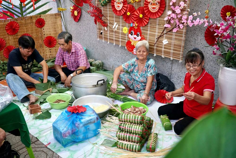 Người dân phường Tân Thuận Tây cùng gói bánh tét trong ngày hội “Xuân đoàn kết - Tết nghĩa tình”. Ảnh: Minh Tâm