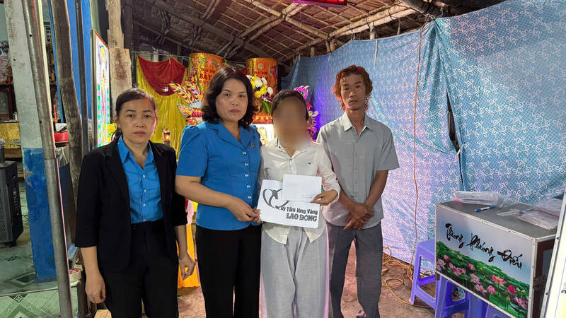 Giving support money to the family of a female worker who died in a traffic accident while on her way home for Tet. Photo: Hoang Loc