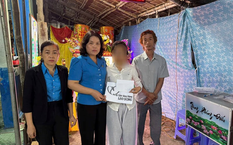 Giving support money to the family of a female worker who died in a traffic accident while on her way home for Tet. Photo: Hoang Loc