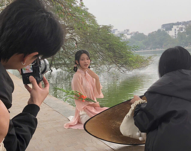 Posing for photos in Ao Dai by Hoan Kiem Lake. Photo: Lan Huong