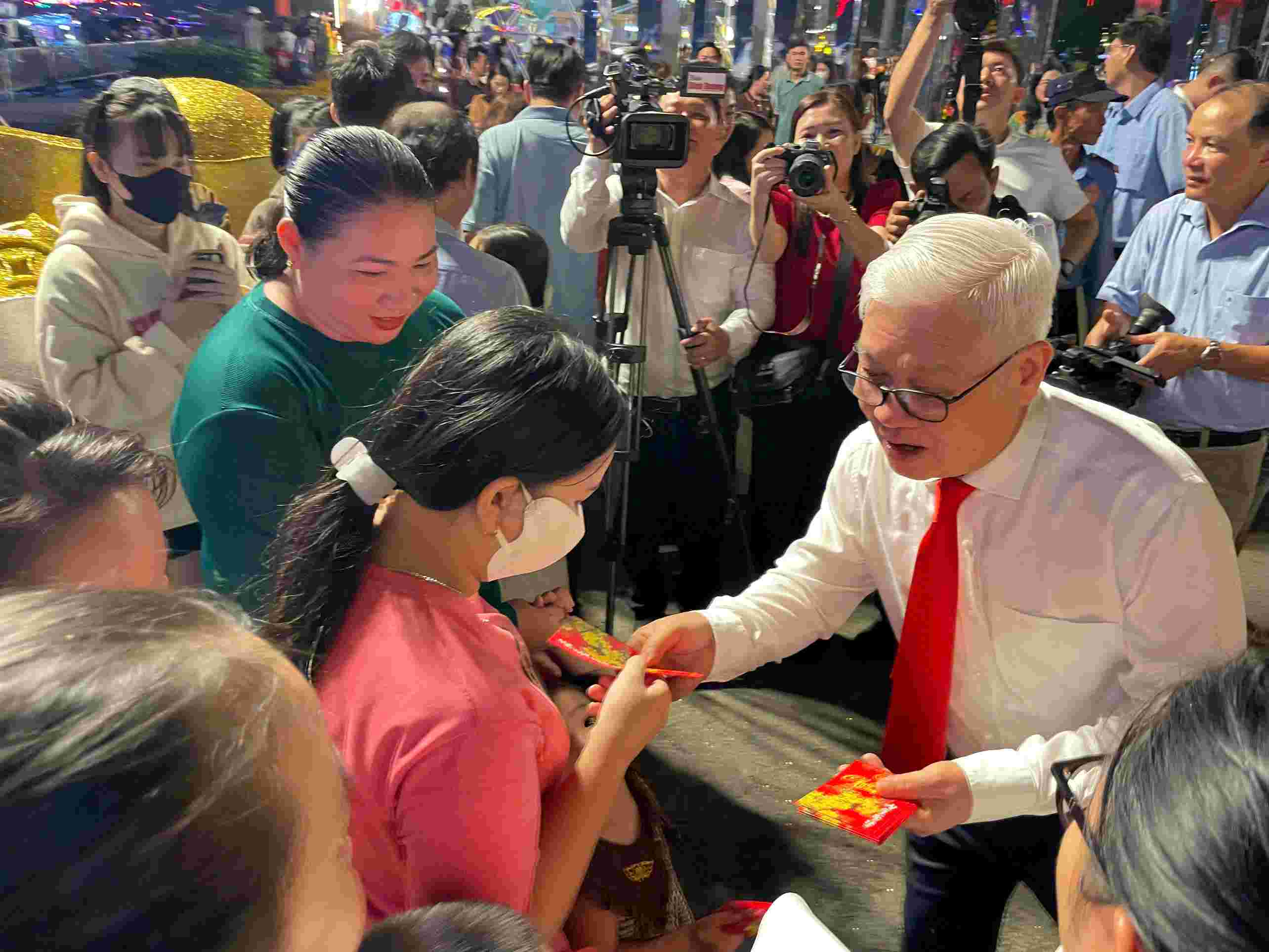 Binh Duong Provincial Party Secretary Nguyen Van Loi gives lucky money to children and people celebrating Tet at the Binh Duong Spring Flower Festival. Photo: Dinh Trong