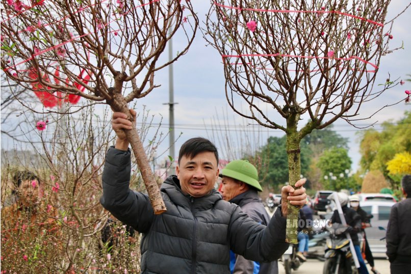 Khách hàng vui mừng khi lựa chọn được nhánh đào ưng ý.