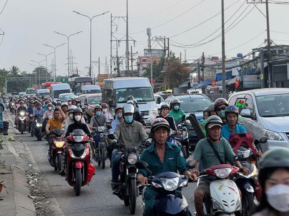 Tai cau Binh Dien, cung cac nut giao quoc lo 1 voi tuyen Nguyen Huu Tri, Bui Thanh Khiet, cac loai oto, xe may xep kin mat duong, chay cham. Nhieu gia dinh chay xe may mang theo linh kinh do dac, qua que. Sau hanh trinh dai duoi tiet troi oi buc, nguoi lon met moi, trong khi nhieu tre nho ngu guc tren yen xe.  