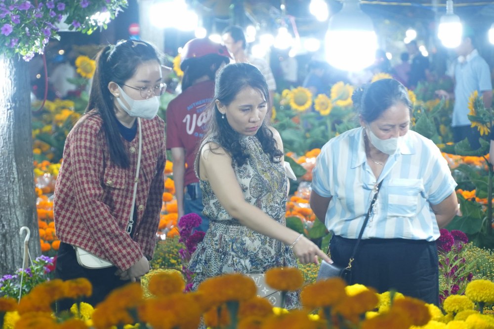 Tại khu vực bán hoa Tết trên đường Trần Văn Hoài, khách tấp nập mua sắm và chở hoa Tết về nhà.