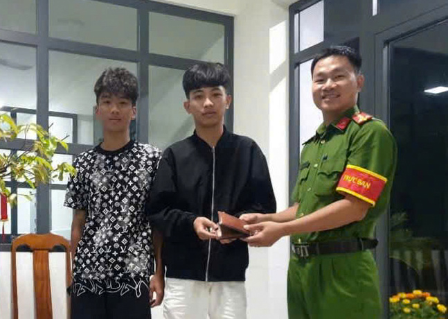 Two students went to the police station to return the property to the person who lost it. Photo: Lam Hong