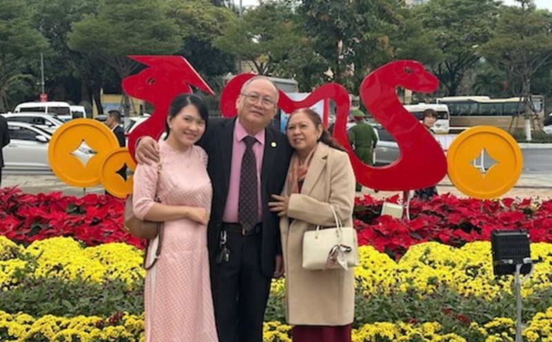 Tourists take photos with their families at Bach Dang flower street. Photo: Nguyen Linh