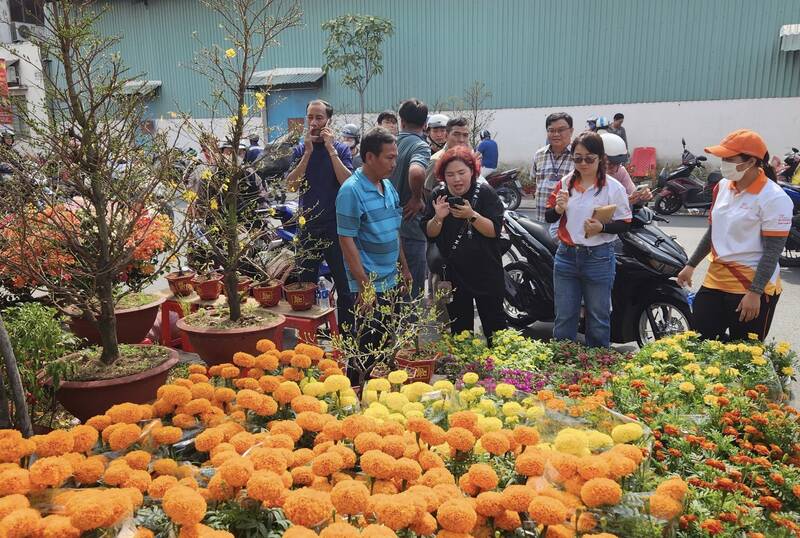 Buying flowers to give to poor families in Ho Chi Minh City on Tet holiday. Photo: Organizing Committee