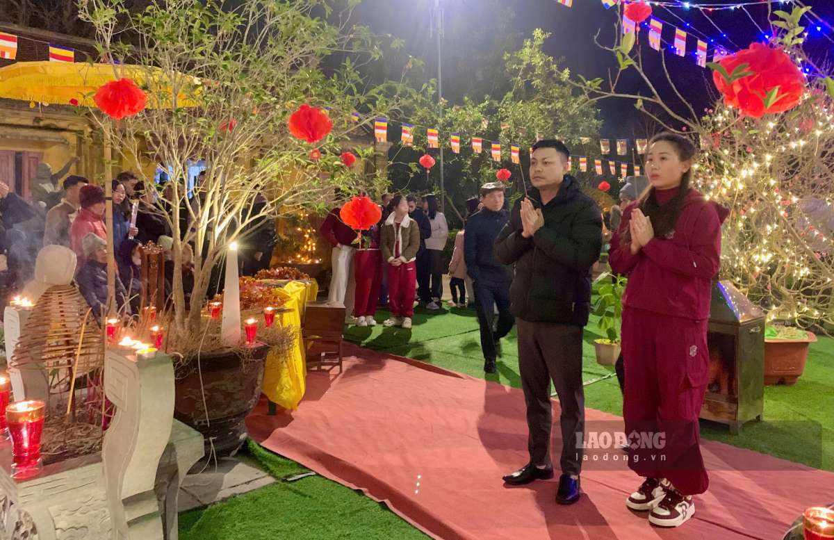 Mr. Nguyen Van Thang and his wife go to pray for luck on New Year's Eve. Photo: Luong Ha