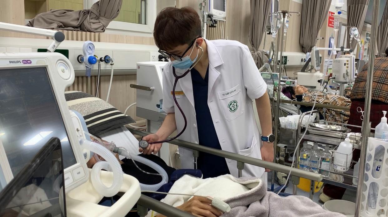 Dr. Nguyen Minh Hieu checks the health condition of a seriously ill patient who was transferred near New Year's Eve at Bach Mai Hospital. Photo: Phuong Anh