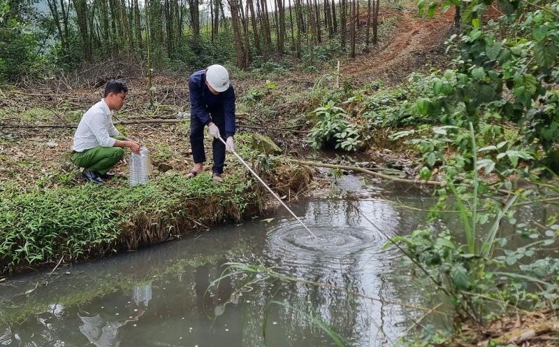 Authorities take samples of wastewater from a pig farm for testing. Photo: Duc Tai.