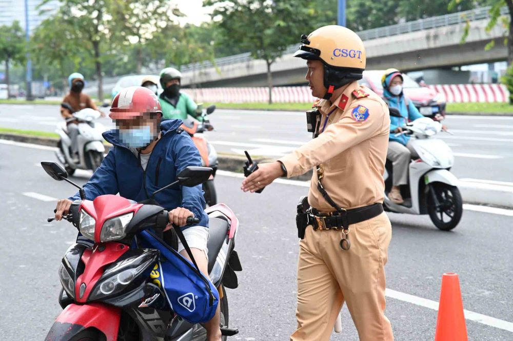 CSGT moi tai xe dieu khien xe qua toc do vao lam viec. Anh: Nguyen Chan