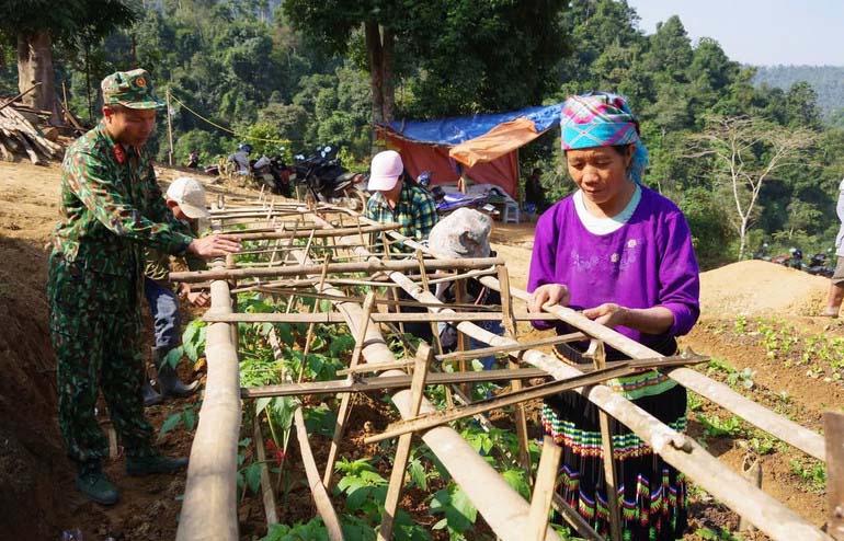 Bộ đội phụ giúp người dân thôn Tà Han ổn định cuộc sống nới tái định cư. Ảnh: Quang Nhất.