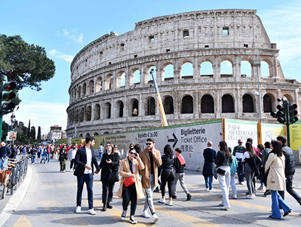 Du khách đi bộ gần khu Đấu trường La Mã ở Rome, Italia. Ảnh: Xinhua