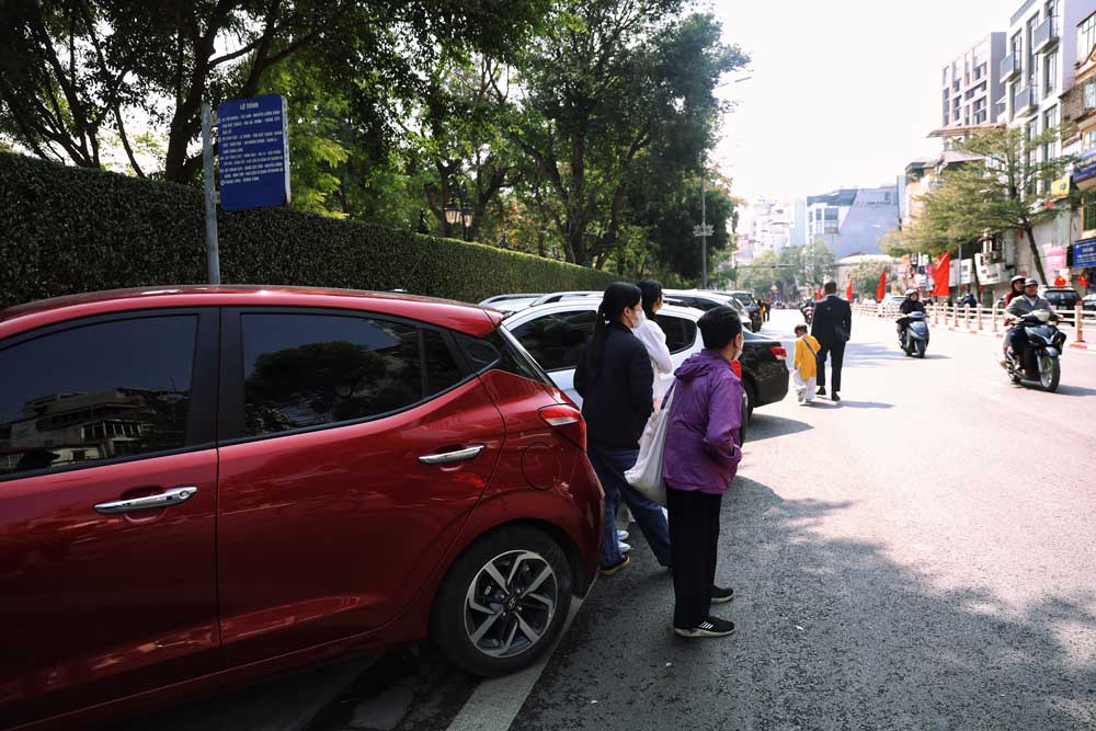 Ba Nguyen Thi Loan (Chuong My, Ha Noi) tham chi phai dung duoi long duong de cho xe buyt, khi diem cho tren via he da bi chiem dung lam cho do xe.