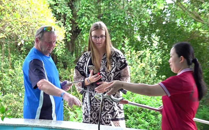 Tourists excitedly experience snake catching in Phu Quoc. Photo: Ta Quang