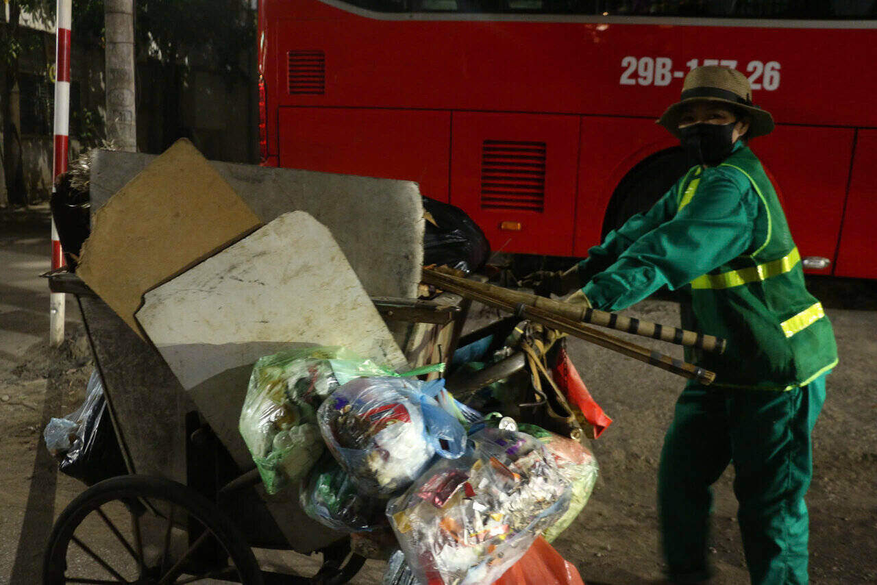 Environmental sanitation workers silently push garbage carts in the dark. Photo: Yen San